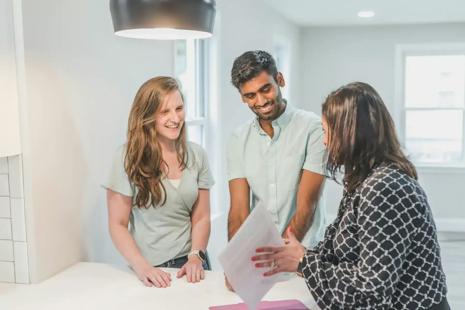 Tenants and agent discussing rental documents, understanding if subletting is legal in Dubai before signing a lease.